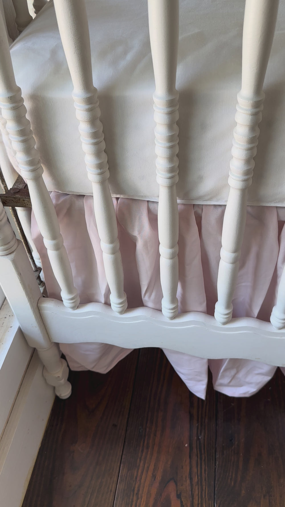 Walking video of the green striped crib rail cover and baby pink farmhouse skirt in the nursery