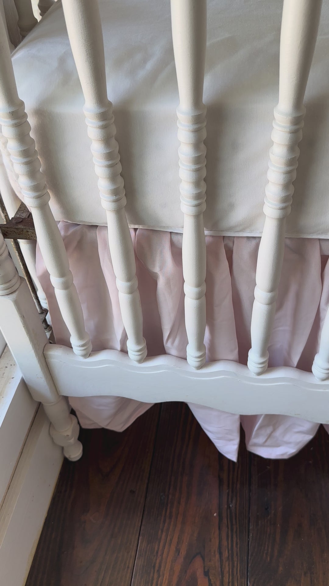 Walking video of the green striped crib rail cover and baby pink farmhouse skirt in the nursery