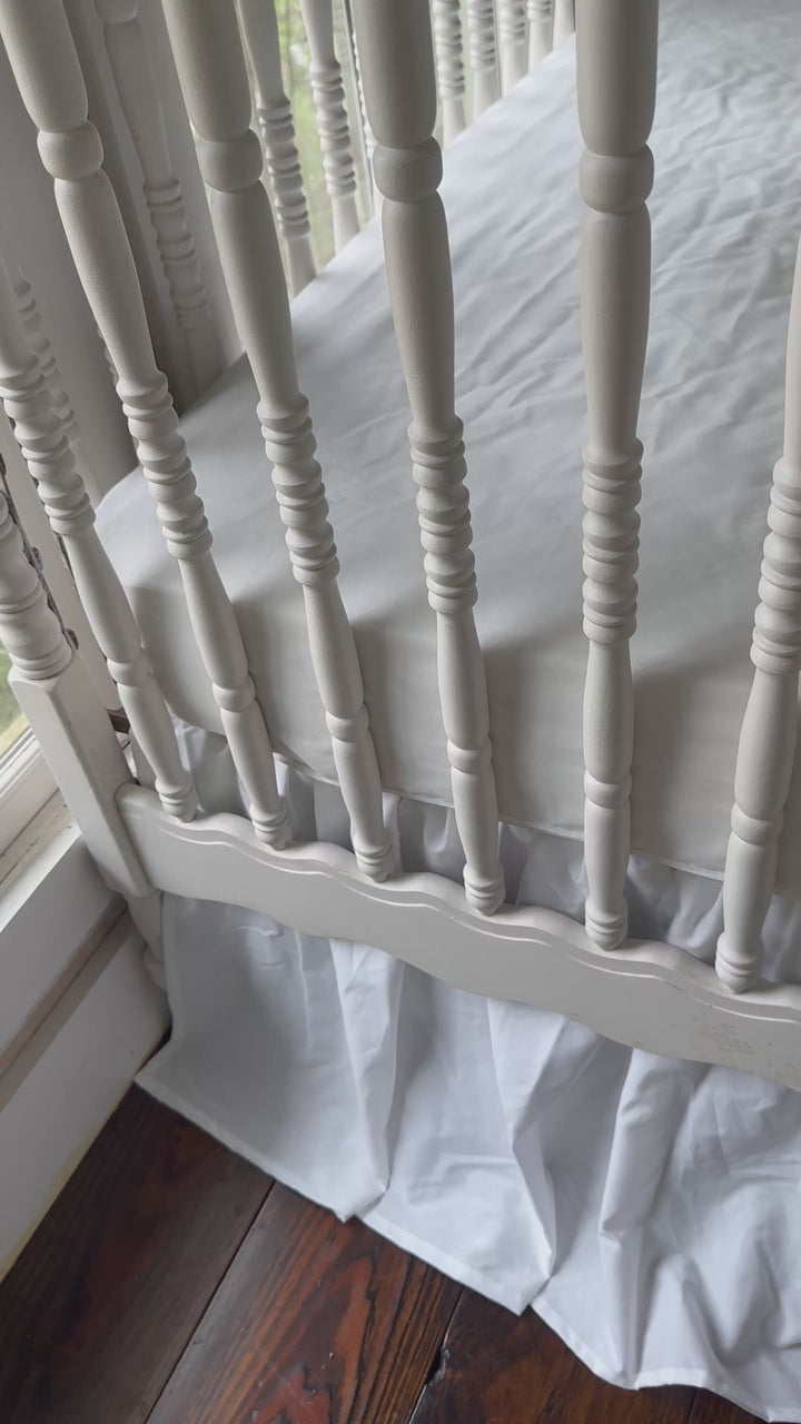 Walking video of the green dot ruffled crib rail cover and white farmhouse crib skirt in the nursery