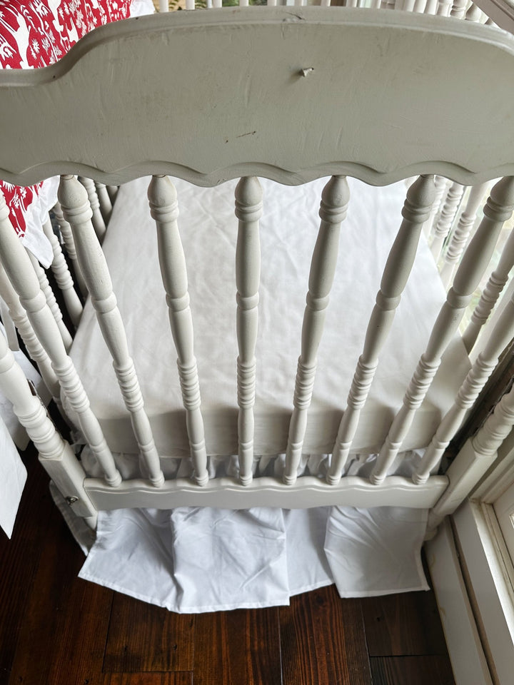 Foot of the crib showing the white farmhouse skirt gathered evenly to the floor