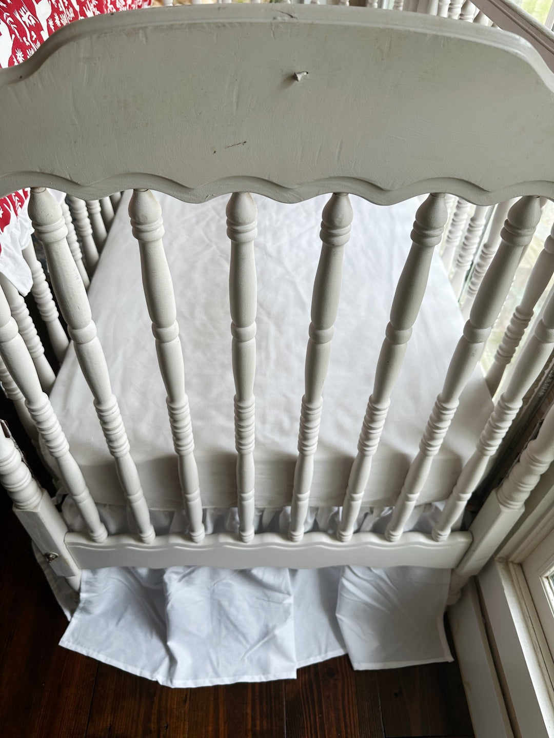 Foot of the crib showing the white farmhouse skirt gathered evenly to the floor