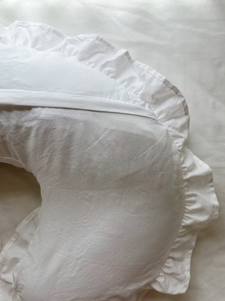 Side view of white ruffled Boppy nursing pillow cover showing the seam