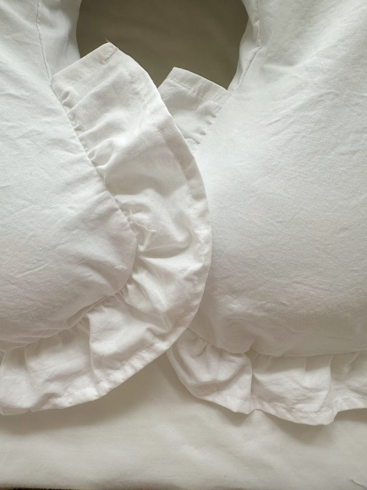 Ruffle edge and center opening detail on a white Boppy pillow cover