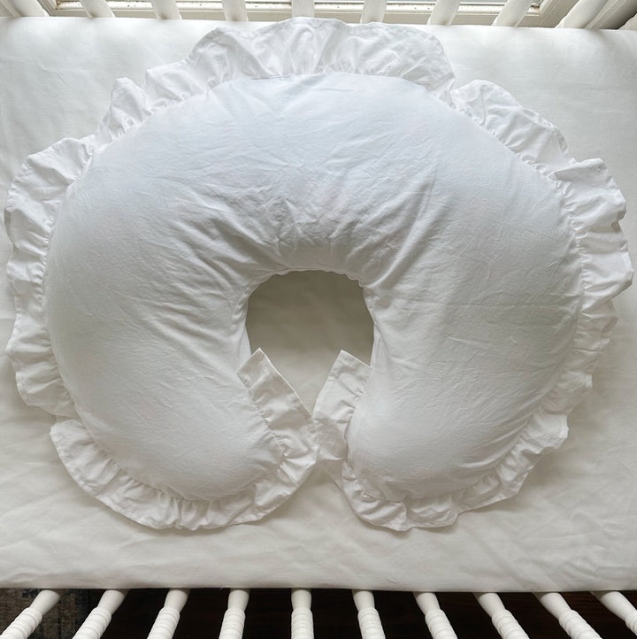 White ruffled Boppy pillow cover in a white crib — High Cotton Textile