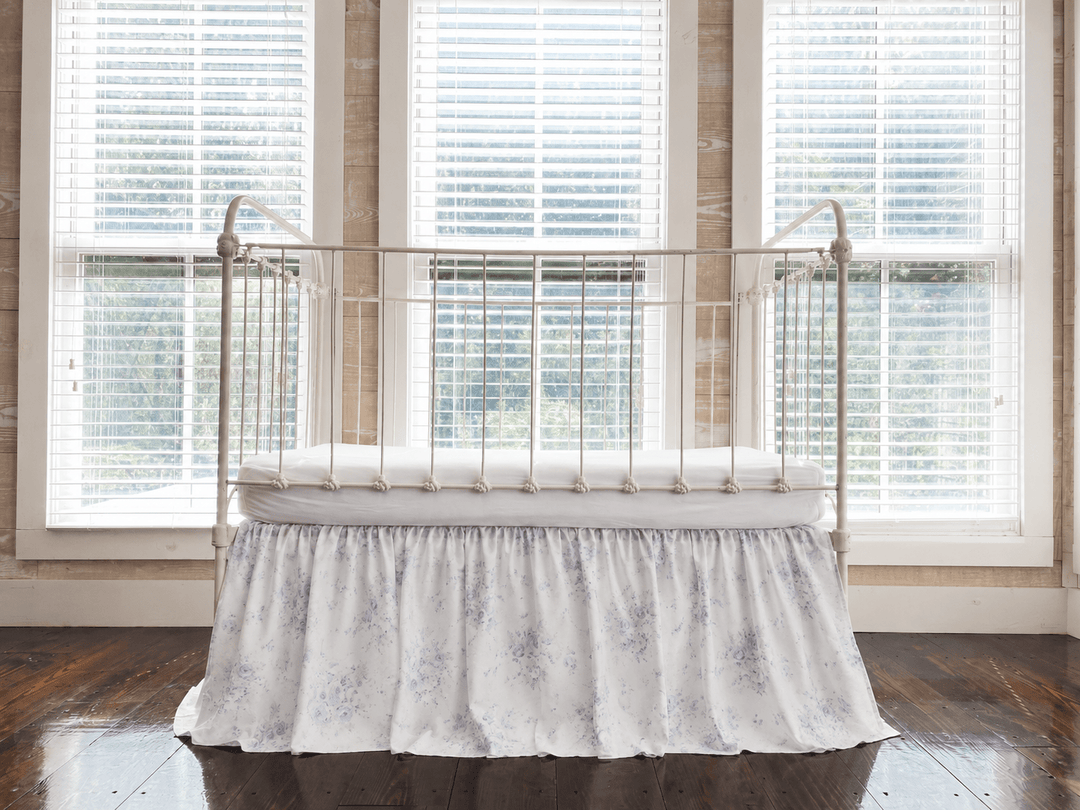 Lavender Shabby Chic Floral farmhouse crib skirt with gathered 20-inch drop, shown on an iron crib