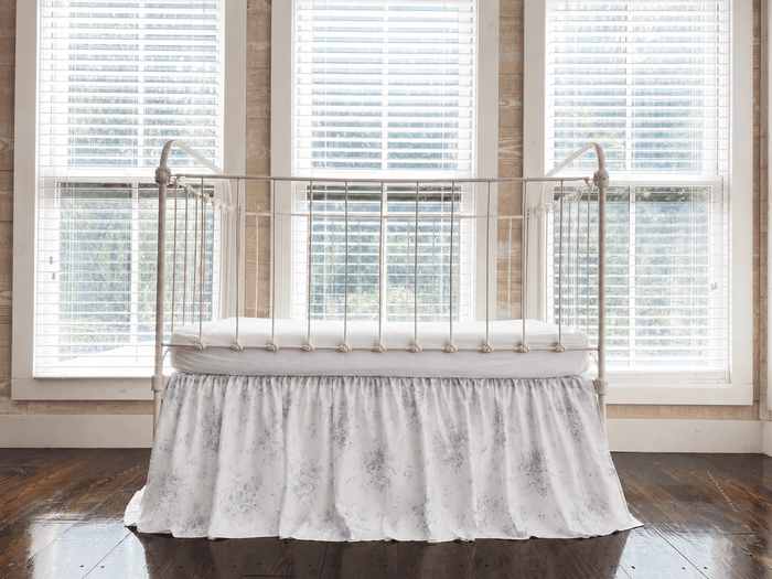 Lavender Shabby Chic Floral farmhouse crib skirt with gathered 20-inch drop, shown on an iron crib