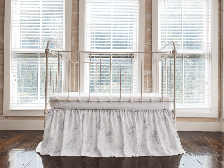 Lavender Shabby Chic Floral farmhouse crib skirt with gathered 20-inch drop, shown on an iron crib