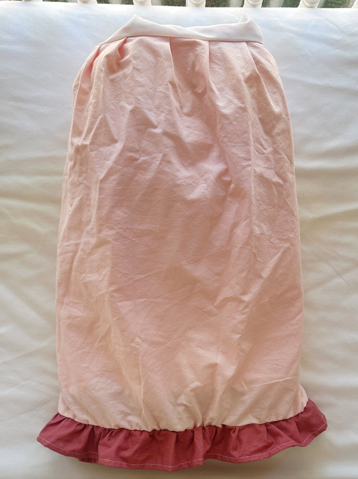 One side of the Sisters Pink & Blush crib skirt laid flat, gathered pink panel with the darker blush ruffle along the hem