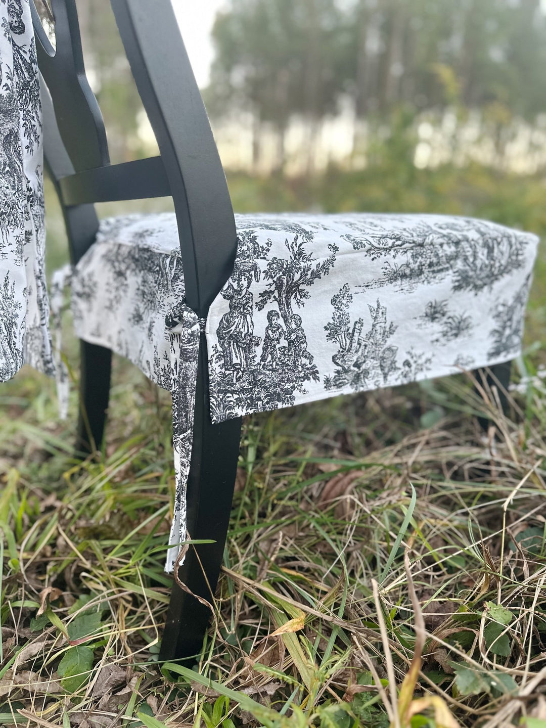 Back corner of the chair slipcover with a dainty toile tie wrapped around the chair leg