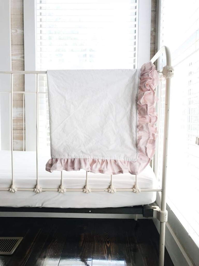 White and baby pink ruffled crib blanket in washed cotton, about 34 by 42 inches