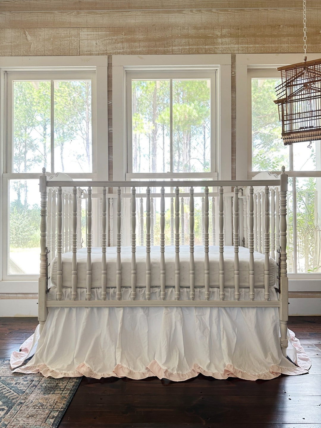 Full nursery view with the scalloped crib skirt centered beneath three windows
