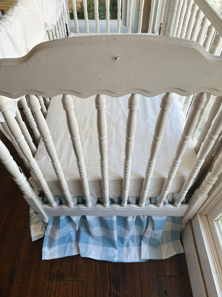 Blue buffalo check farmhouse crib skirt with a 20 inch gathered drop shown on a standard crib