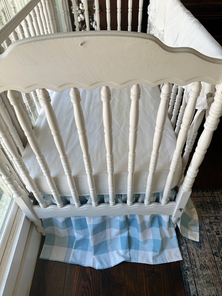 End view of the blue buffalo check crib skirt and white fitted crib sheet in a farmhouse nursery