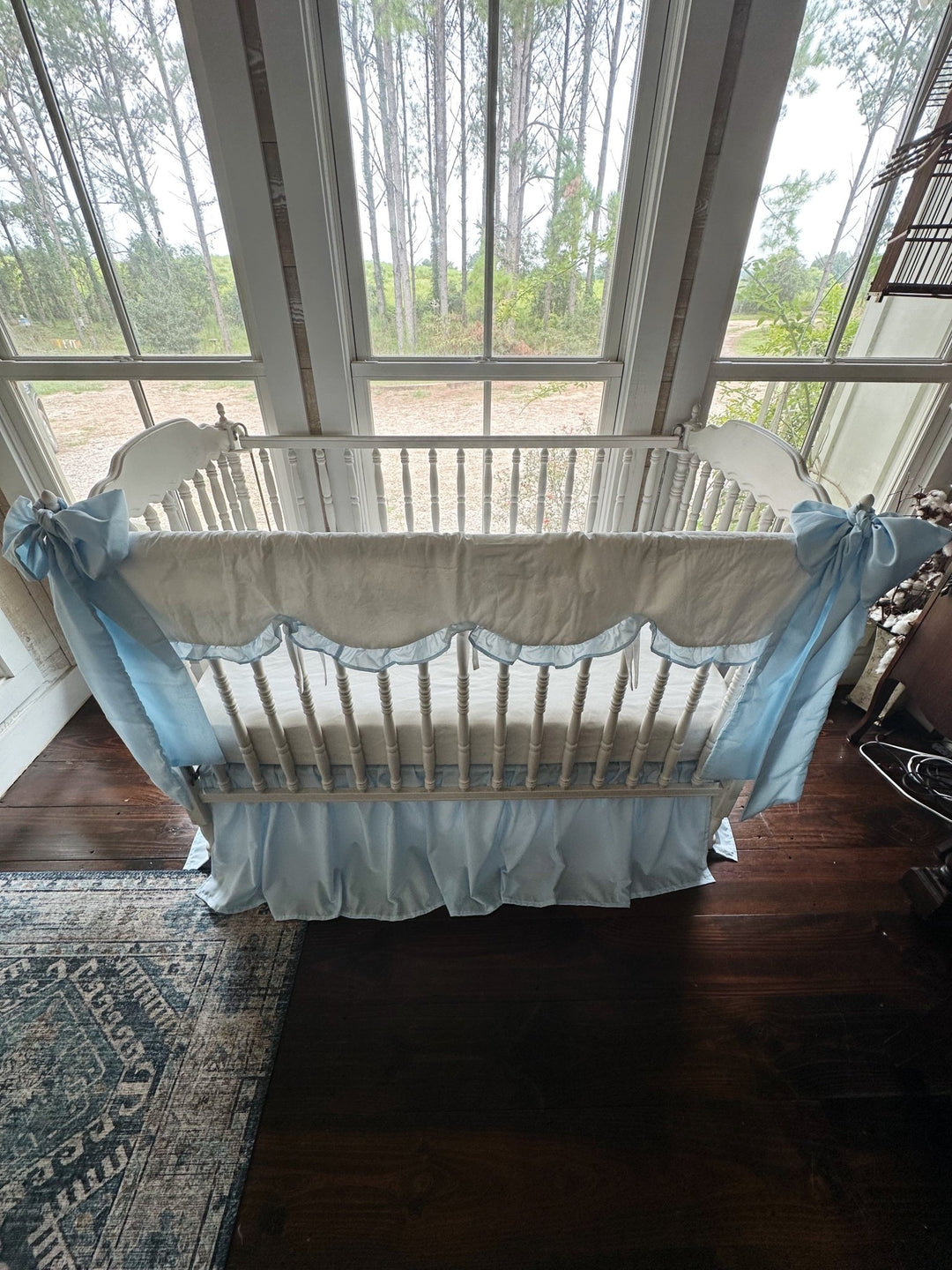High angle of the full heirloom blue crib bedding set with bows tied at both corner posts
