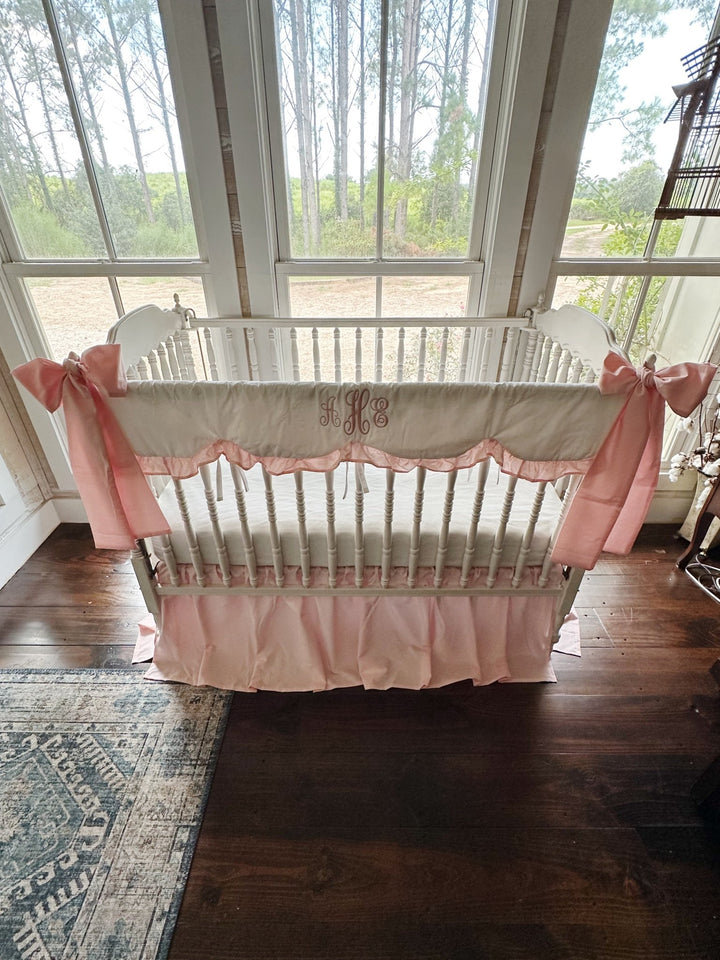 Sisters Pink scalloped crib rail cover and farmhouse crib skirt set shown with two large crib bows