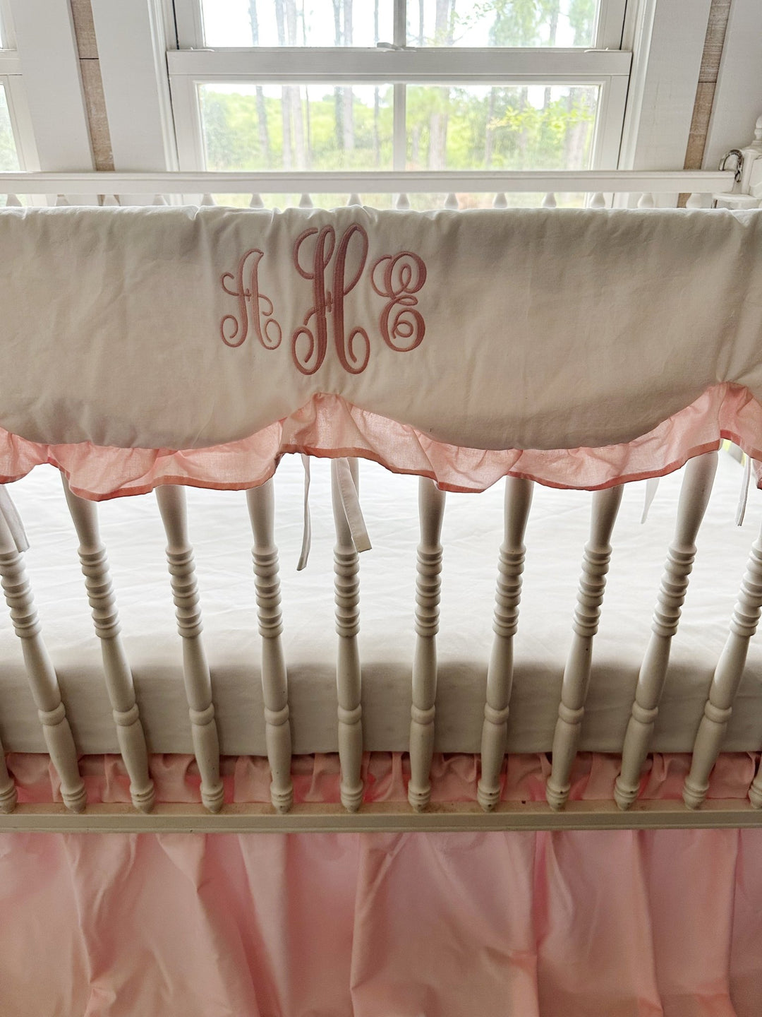 Monogrammed white scalloped crib rail cover with a Sisters Pink ruffle trim and white cotton ties