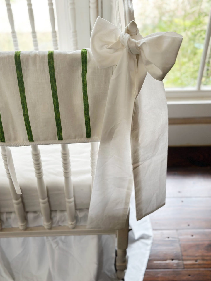 End of the striped rail cover meeting a white sash, its tails falling toward the floor