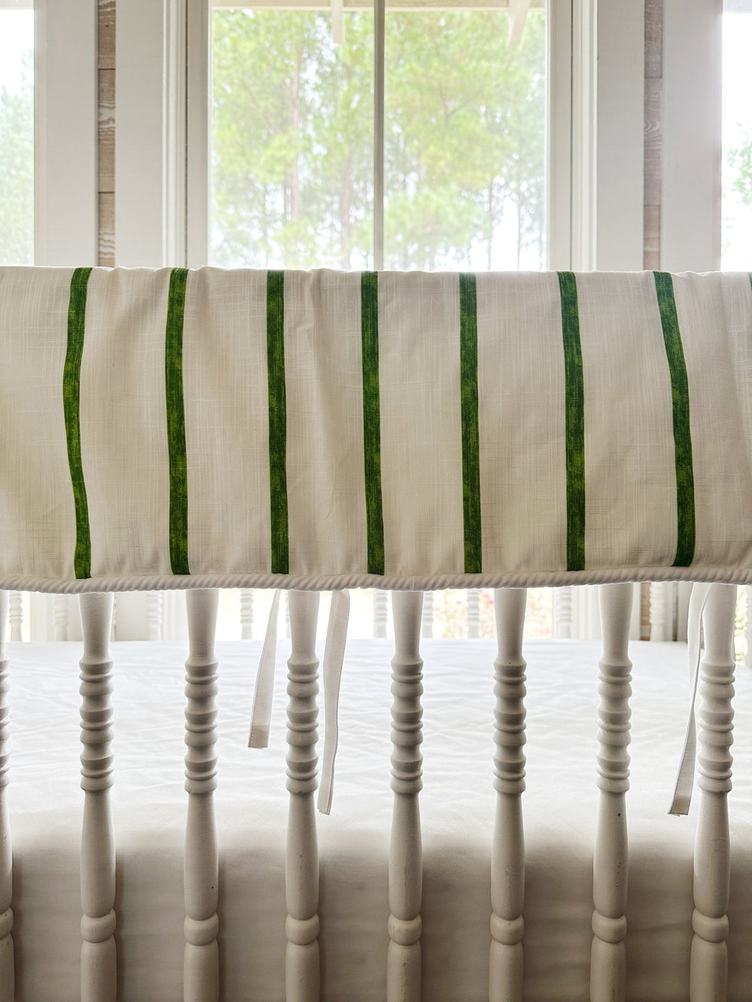 Close view of the painted green stripes, the white cording along the bottom edge and one slim white tie