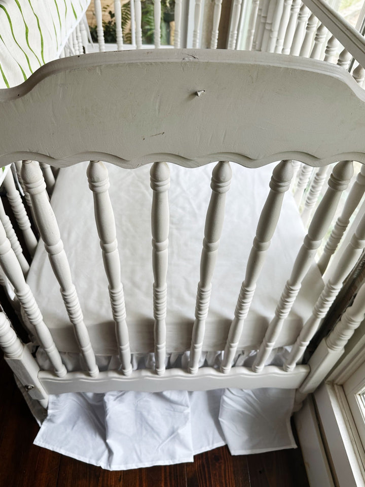 End of the crib from above, white farmhouse skirt falling to a 20-inch drop