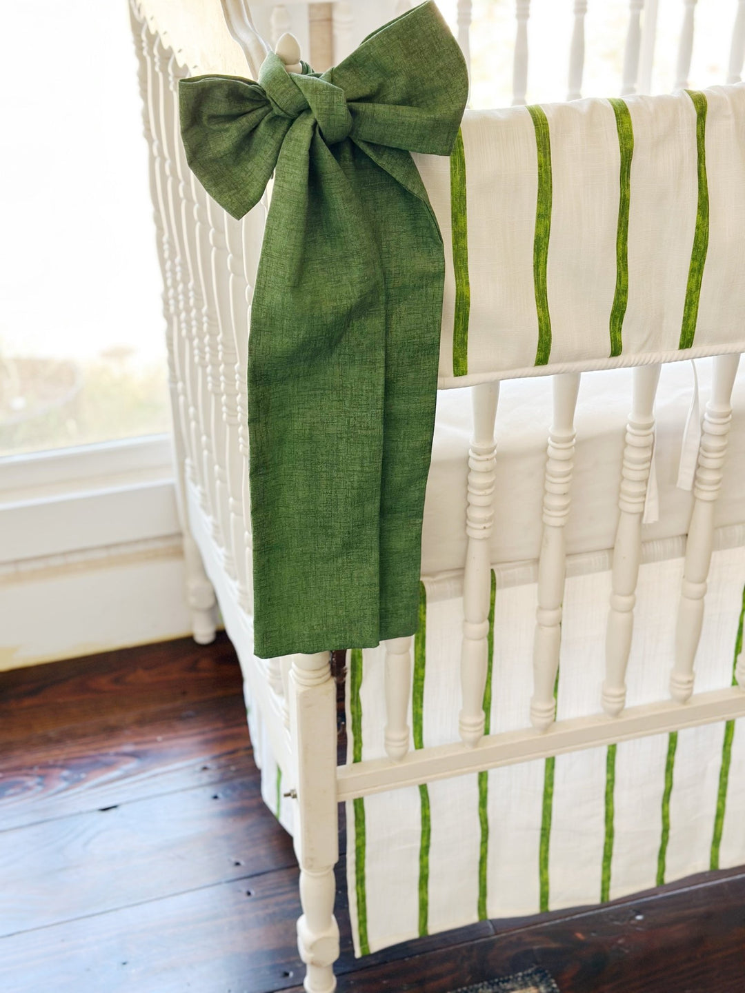 Cypress green sash knotted at the corner post, its long tails falling past the striped skirt