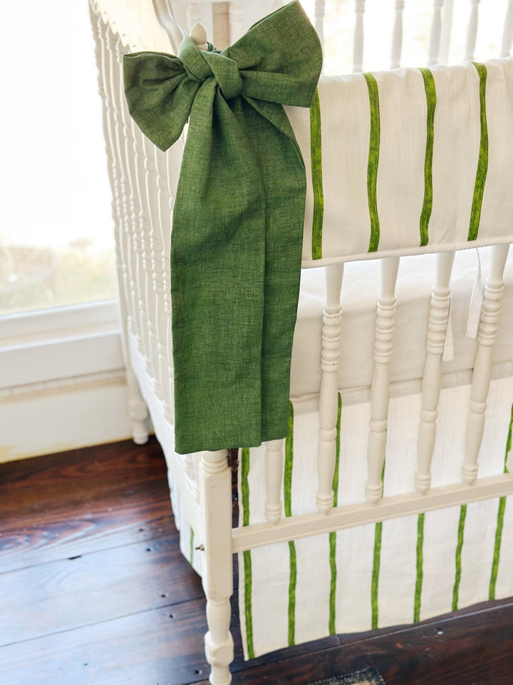 Cypress green sash knotted at the corner post, its long tails falling past the striped skirt