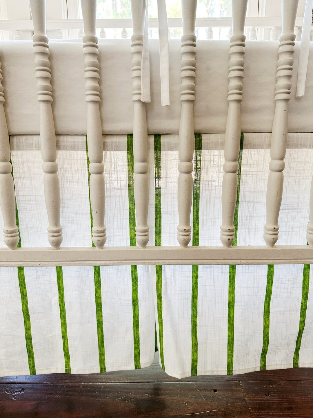 The tailored skirt's corner pleat and green stripes seen between the turned spindles