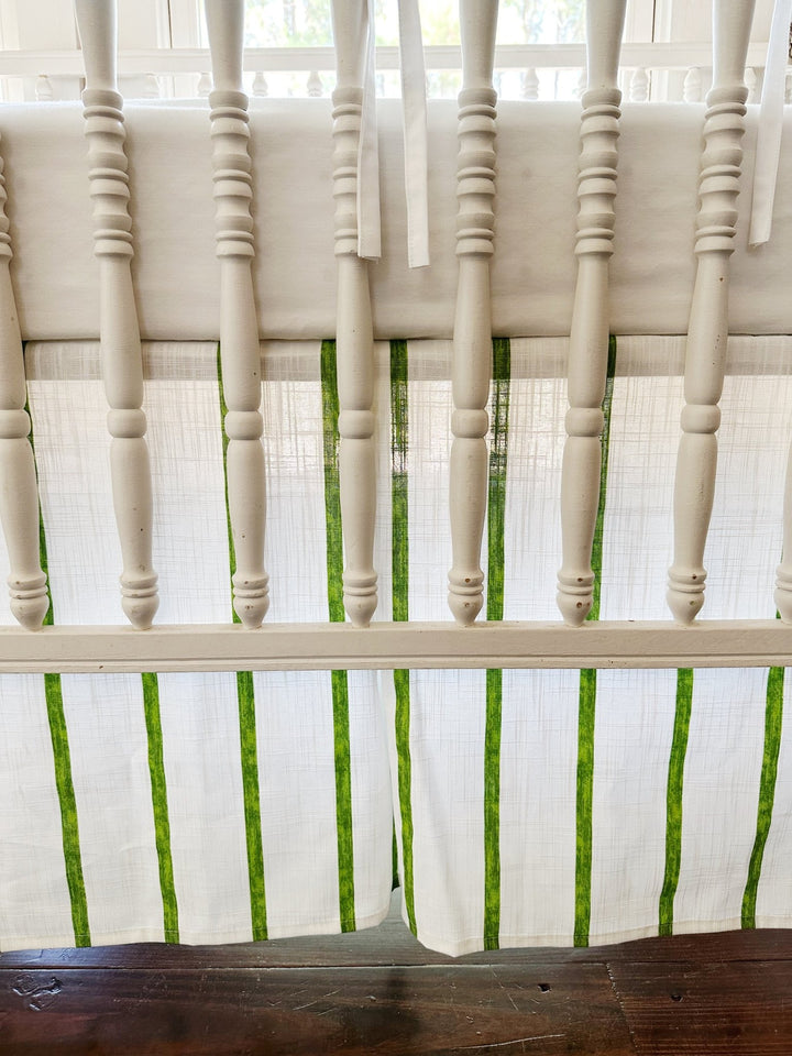 The tailored skirt's corner pleat and green stripes seen between the turned spindles