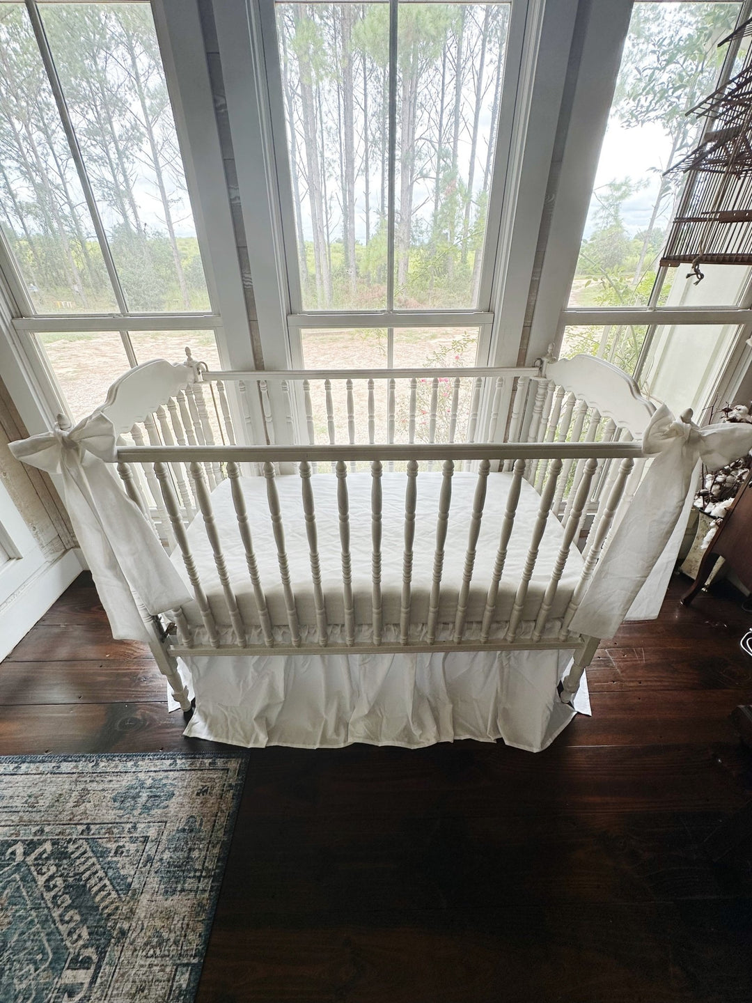 Looking down over the crib at the white skirt and both bows in place