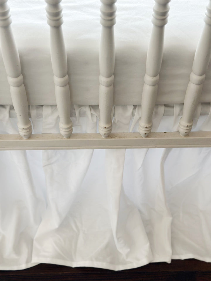 Detail of the soft even gathers along the top of the white farmhouse crib skirt