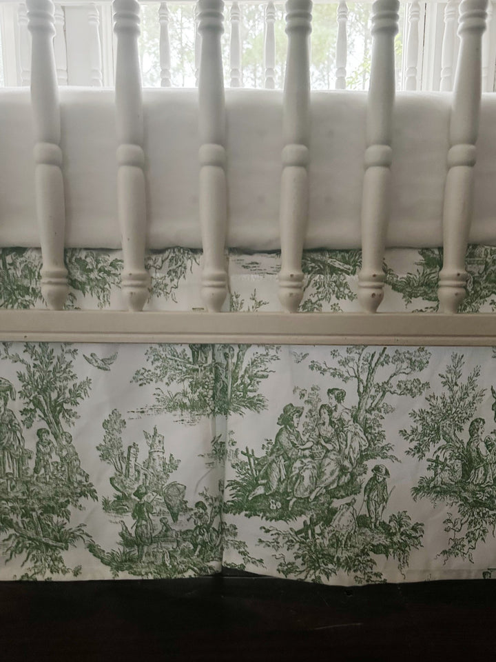 Detail of the white rail cover above the green toile skirt, showing the pastoral print and box pleat