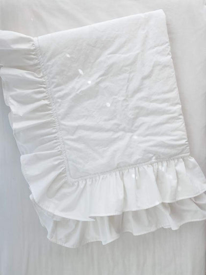 White ruffled baby crib quilt in washed cotton, about 34 by 42 inches