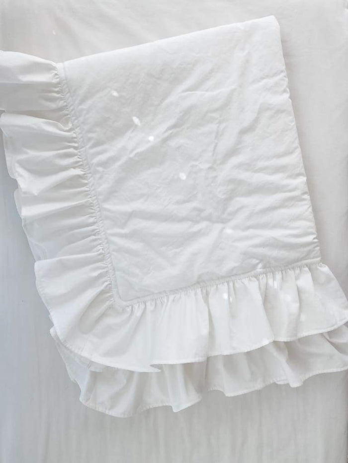 White ruffled baby crib quilt in washed cotton, about 34 by 42 inches