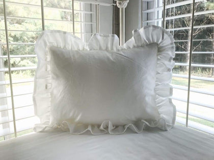 White ruffled crib pillow in washed cotton