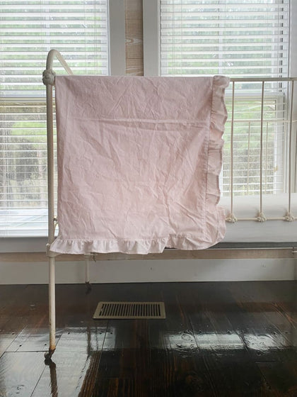 Baby pink crib blanket with a matching ruffle border in washed cotton