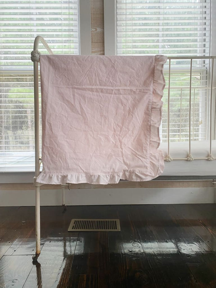 Baby pink crib blanket with a matching ruffle border in washed cotton