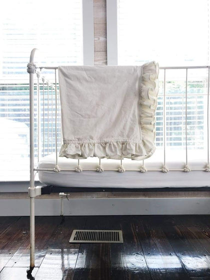 Porcelain ruffled crib blanket in washed cotton, about 34 by 42 inches