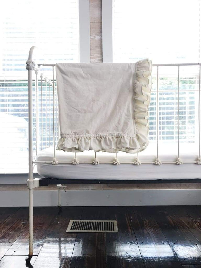 Porcelain ruffled crib blanket in washed cotton, about 34 by 42 inches