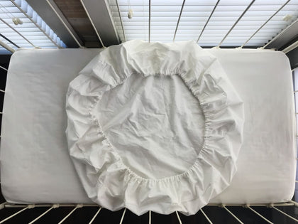 White fitted round crib sheet in washed cotton