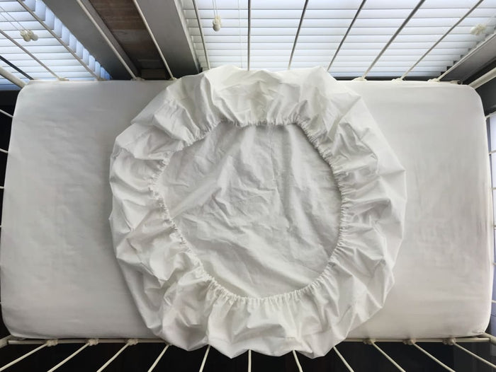 White fitted round crib sheet in washed cotton